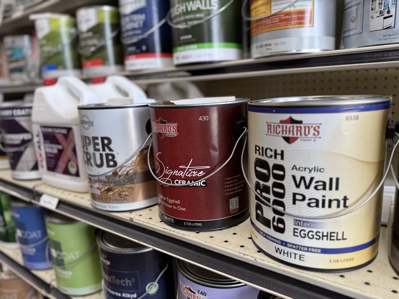 Wall of paint cans on shelves